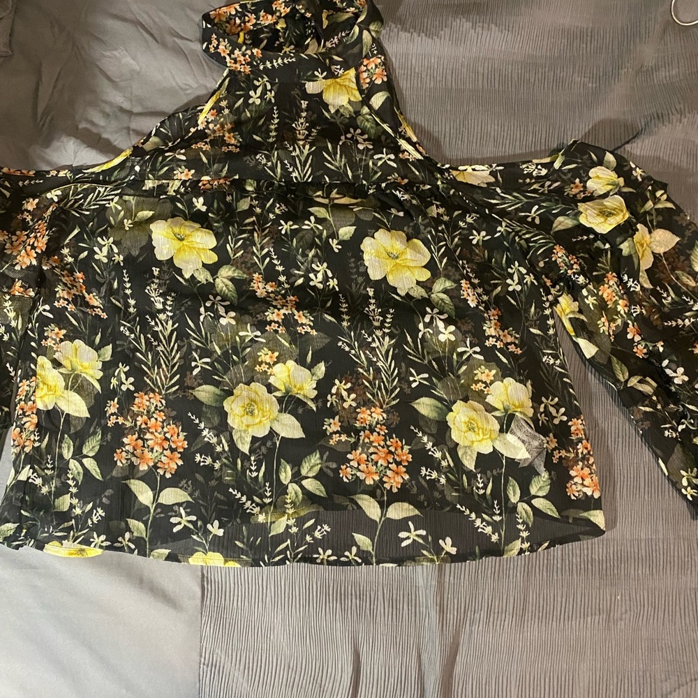 Sheer, floral cutout  blouse with ruffle detail and toes on the back.